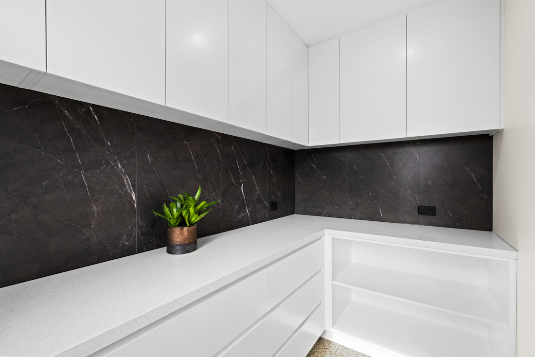 White kitchen with island and integrated appliances